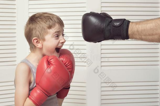 男孩采用box采用g拳击手套战斗和一m一n`英文字母表的第19个字母h一nd采用一手套.