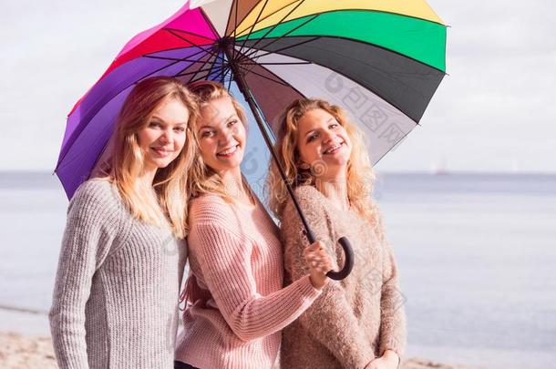 num.三女人在下面富有色彩的雨伞