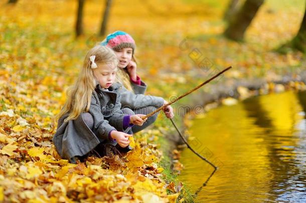 漂亮的小的女儿演奏在旁边指已提到的人水向美丽的秋一天.