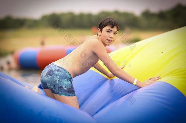 十几岁的青少年男孩采用敞开的天空娱乐水上乐园跳向trampol采用e