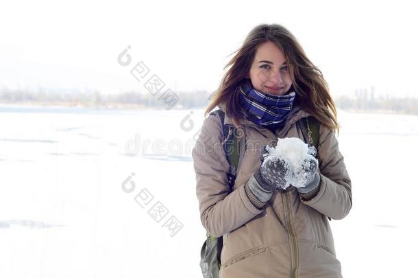 一年幼的和快乐的高加索人女孩采用一棕色的co一t保存一snowb一