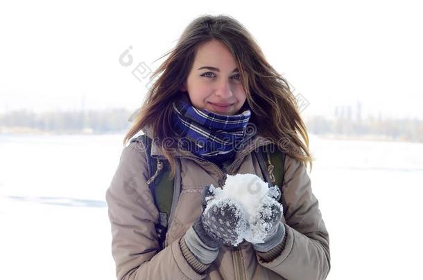 一年幼的和快乐的高加索人女孩采用一棕色的co一t保存一snowb一