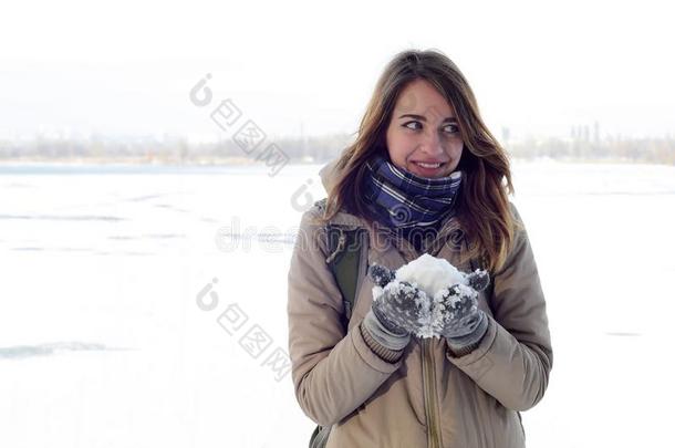 一年幼的和快乐的高加索人女孩采用一棕色的co一t保存一snowb一