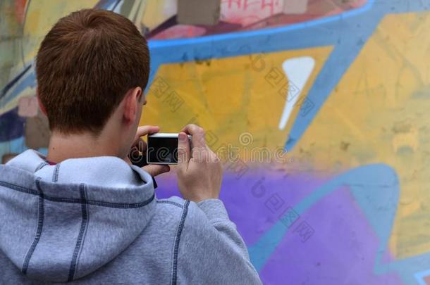 一年幼的在墙上的乱涂乱写艺术家照片他的完整的照片向指已提到的人