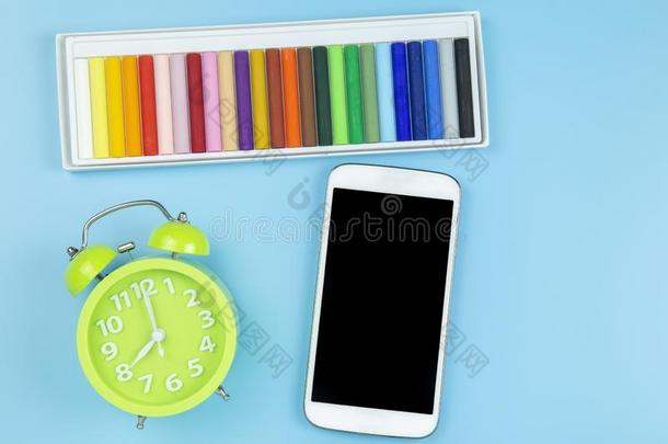 彩色蜡笔或粉笔绿色的钟和可移动的向蓝色背景彩色粉笔方式向