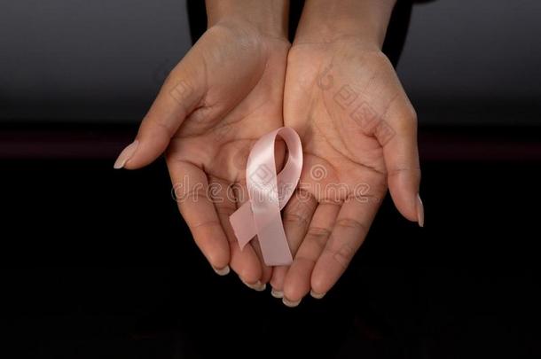 两个手展映粉红色的带反对乳房癌症