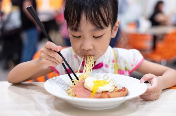亚洲人中国人小的女孩吃面条和筷子