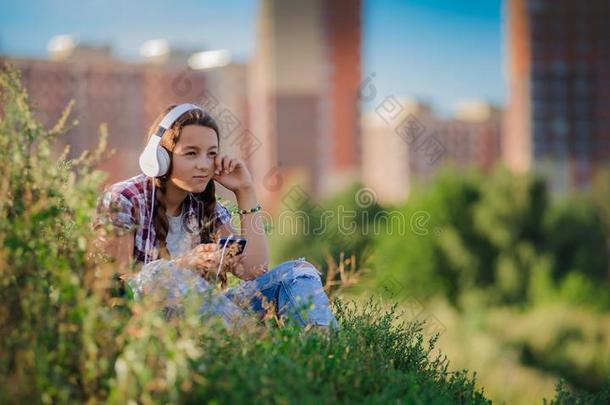 年幼的女孩收听的向音乐向headph向es,都市的大街方式,