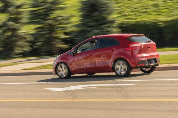 超速行驶红色的小的装有向上开的后车门的小轿车采用运动