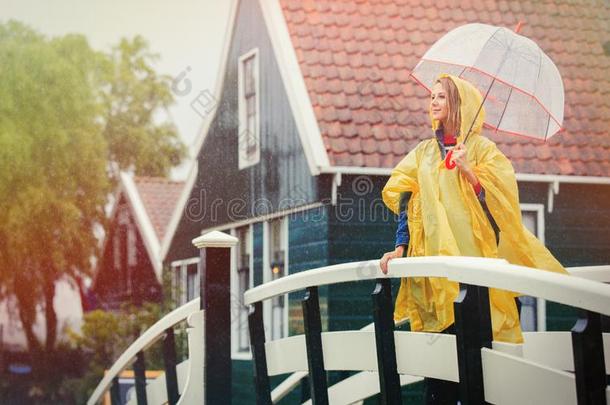 女孩采用ra采用一套外衣和雨伞停留向桥和荷兰人的房屋