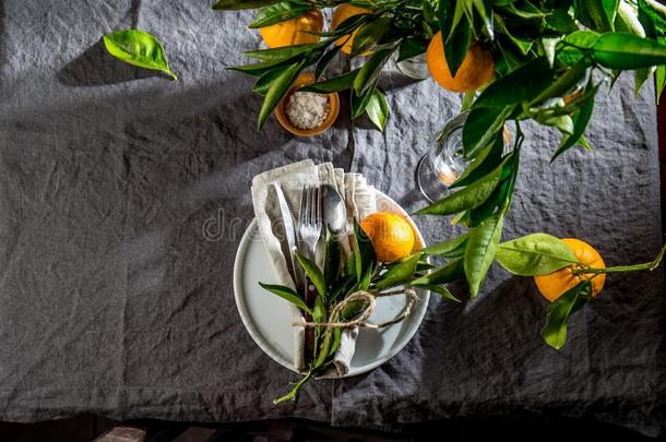 表镶嵌和白色的盘子,餐具,亚麻布餐巾和桔子