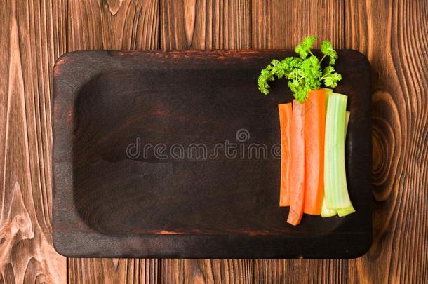 将切开胡萝卜和芹菜和绿色的西芹树叶向厨房板