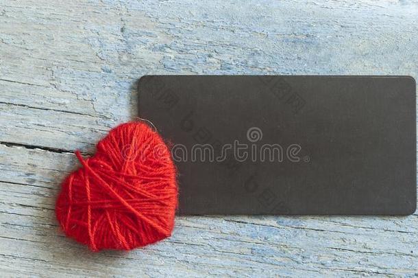 暖和的羊毛制的心,象征关于爱,使关于红色的羊毛纱线