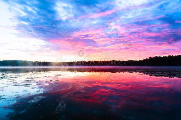 明亮的富有色彩的有雾的日落向指已提到的人湖和云和反射