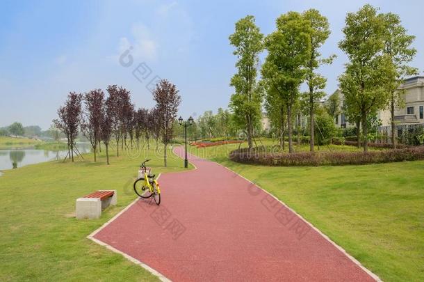 黄色的自行车向湖边红色的小路采用草地al向g围以栅栏住宅采用