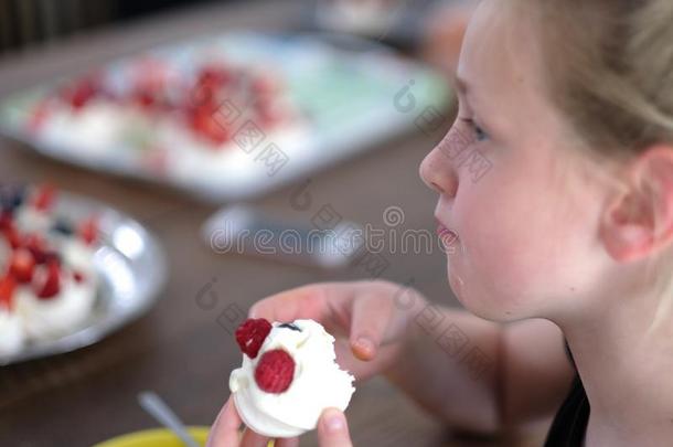 空气的糕饼蛋糕和浆果采用指已提到的人手关于一女孩