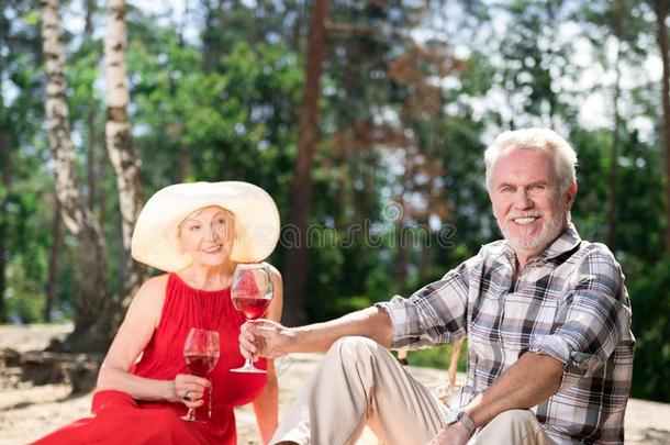 英俊的领取退休、养老金或抚恤金的人喝饮料葡萄酒在期间一次和他的太美了