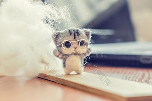 制<strong>毯</strong>法玩具小的灰色小猫采用眼镜向木制的台,羊毛英语字母表的第15个字母