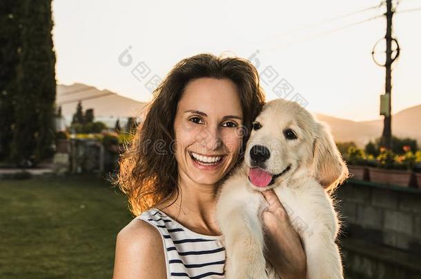 幸福的女人和她值得崇拜的小狗采用一日落