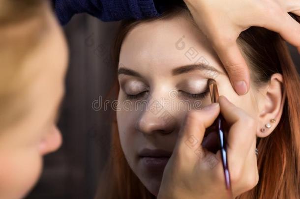化妆艺术家准备的年幼的美丽的女人.关-在上面眼线膏