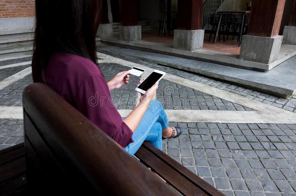 女人佃户租种的土地信誉卡片和使用智能手机为购物安利