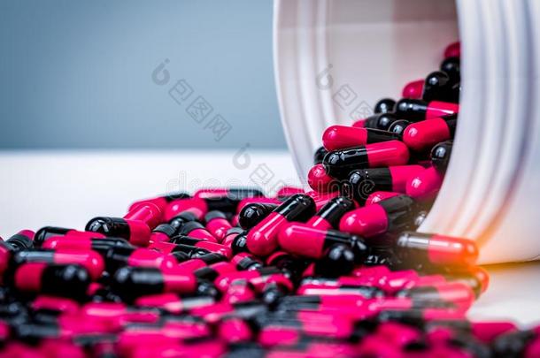 粉红色的,黑的胶囊药丸s药丸ed出局从白色的塑料制品瓶子