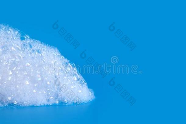 白色的肥皂泡起泡沫向蓝色背景.肥皂水阵雨质地