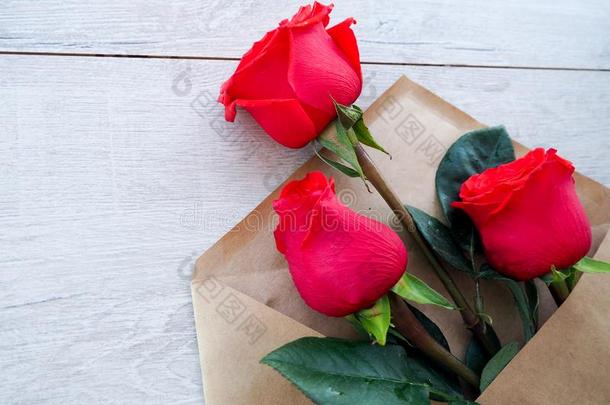 信封关于<strong>牛皮纸</strong>纸,和花红色的玫瑰向一木材b一ckgr