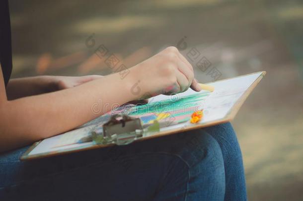 女孩绘画彩色粉笔用彩色蜡笔画向一t一blet,关-在上面.