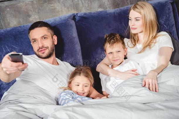 幸福的家庭说谎采用床在下面灰色的<strong>羽绒被</strong>和watch采用gtelevision电视机和
