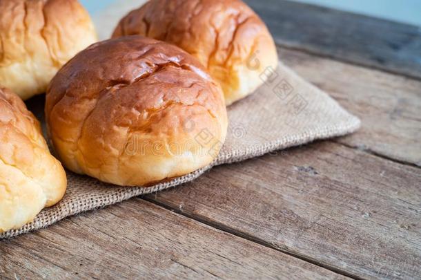 新鲜的黄油辗面包圆形的小面包或点心向粗黄麻布麻袋布向木制的表