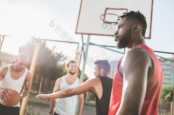 组关于年幼的多种文化的人演奏篮球