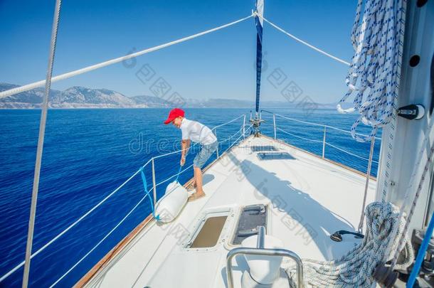 小的男孩向板关于帆船运动快艇向夏巡游.