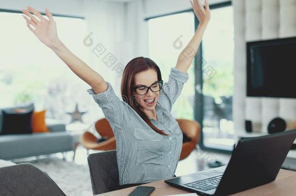 幸福的现代的女人获胜在便携式电脑