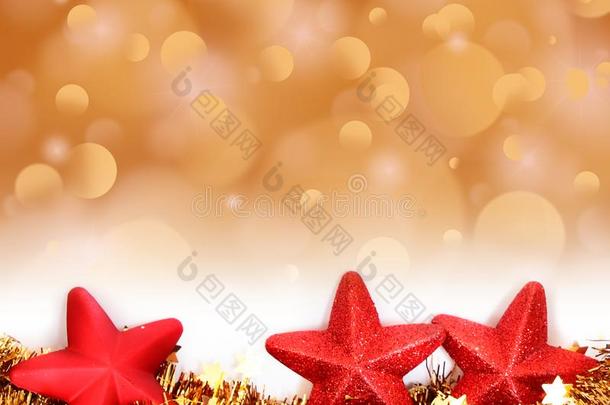 圣诞节金色的焦外成像背景和红色的星装饰