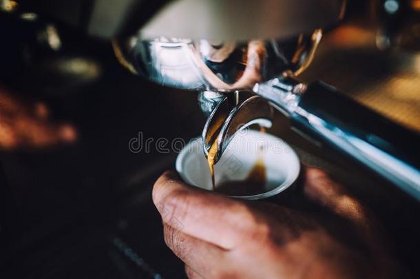 咖啡馆准备咖啡的员工男人和浓咖啡机器准备的新鲜的英语字母表的第5个字母