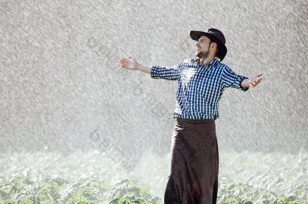 男人湿的在下面雨农场主帽子享有祈祷幸福的打翻重的湿的