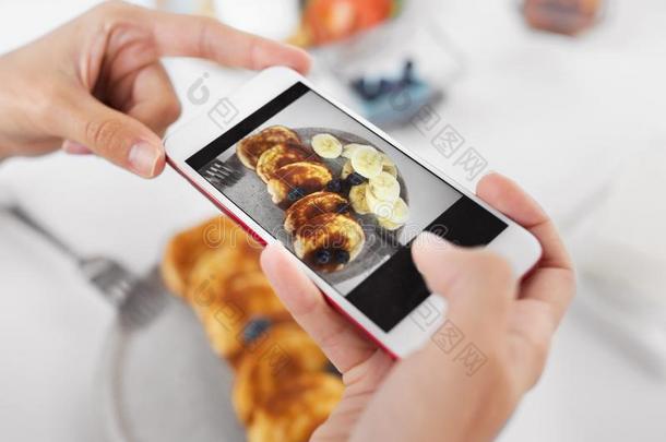 手和智能手机摄影食物