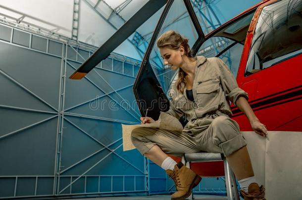 年幼的女人直升机飞行员或技工阅读地图.直升机