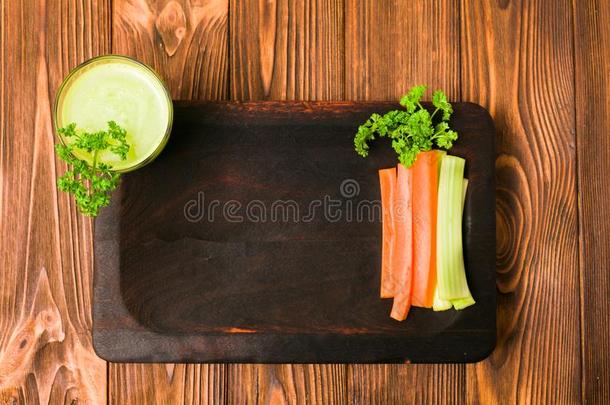 将切开胡萝卜和芹菜和绿色的新鲜的果汁和西芹树叶