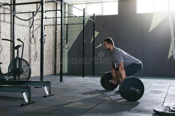 <strong>去死吧</strong>.有关运动的男人举起杠铃行在健身房