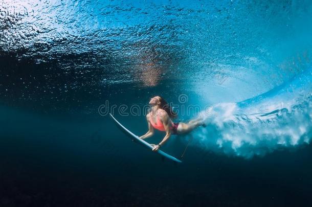 专业的冲浪运动员女人和冲浪板潜水在水中的和家伙