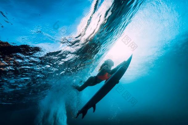 冲浪运动员女孩和冲浪板潜水在水中的和乐趣在下面大的ocean海洋