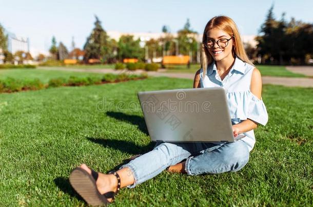 幸福的学生,年幼的女人工作的向便携式电脑采用公园sitt采用g向