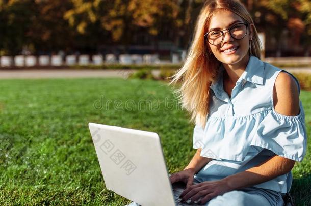 幸福的学生,年幼的女人工作的向便携式电脑采用公园sitt采用g向
