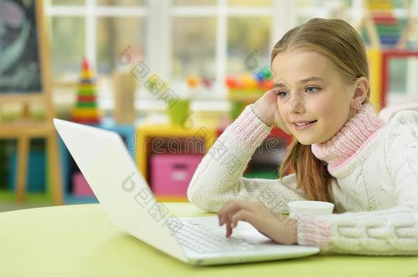肖像关于小的女孩使用便携式电脑在期间一次