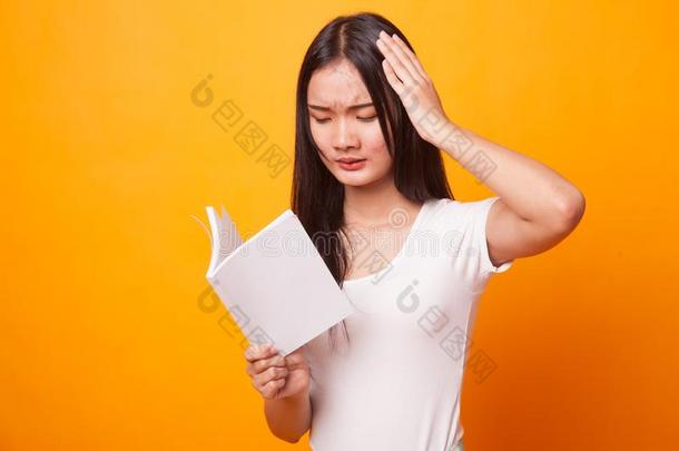 年幼的亚洲人女人得到头痛阅读一书.