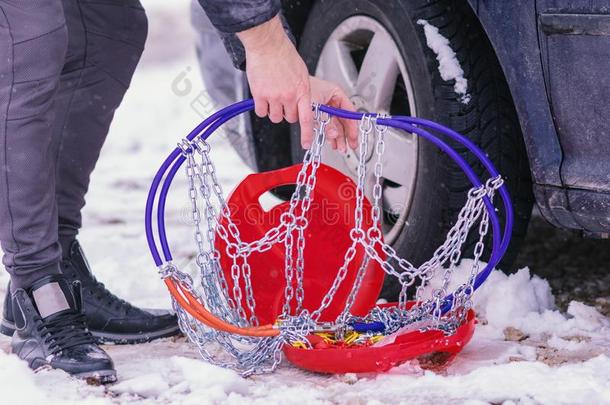 男人安装雪链向指已提到的人轮子关于汽车.