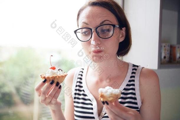 女孩吃美味的蛋糕,一次在旁边指已提到的人窗,甜的食物和英语字母表的第16个字母