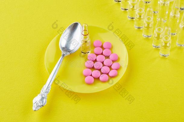 勺和粉红色的药片向茶<strong>杯托</strong>,一次用量的针剂向黄色的背景